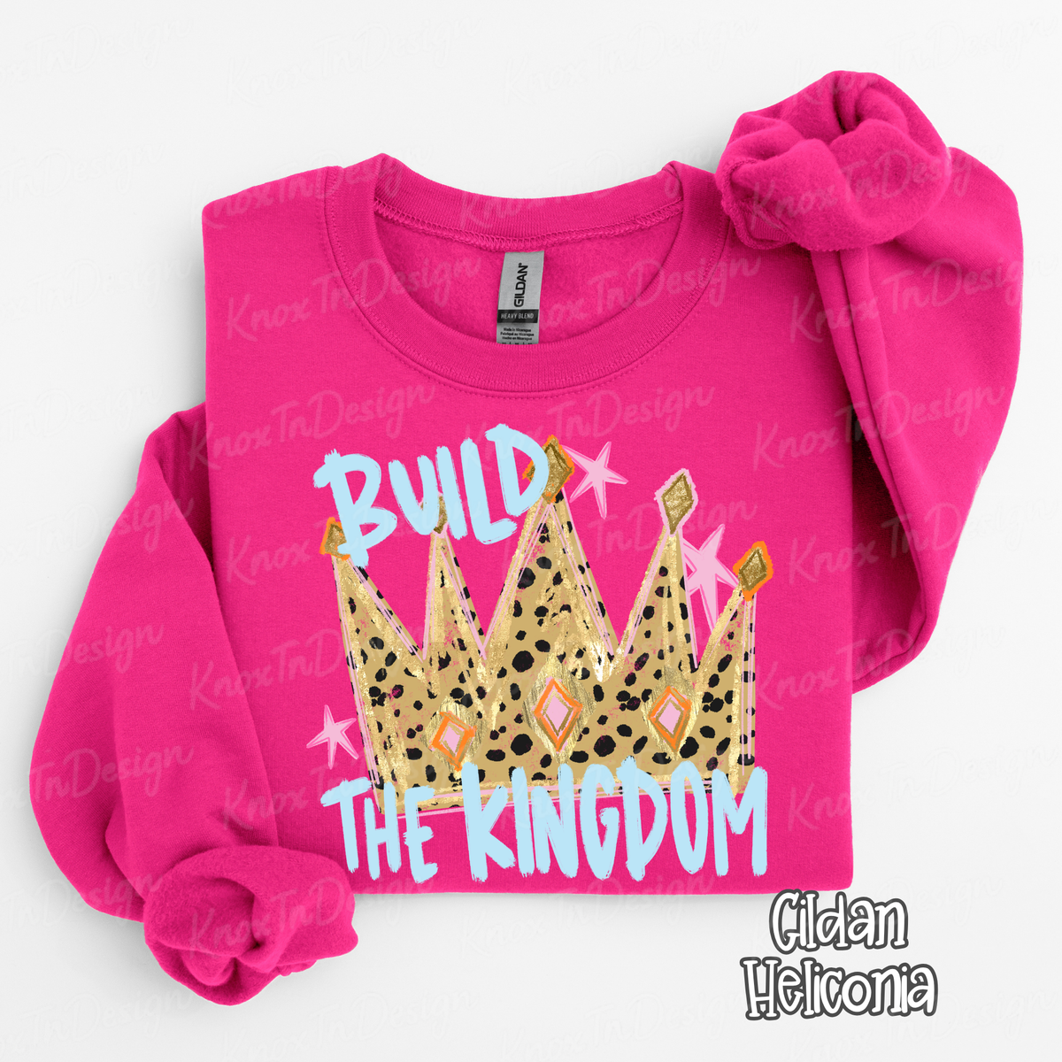 Pink Sweatshirt featuring a colorful crown graphic with the words Build the Kingdom in light blue lettering with pink and gold accents.