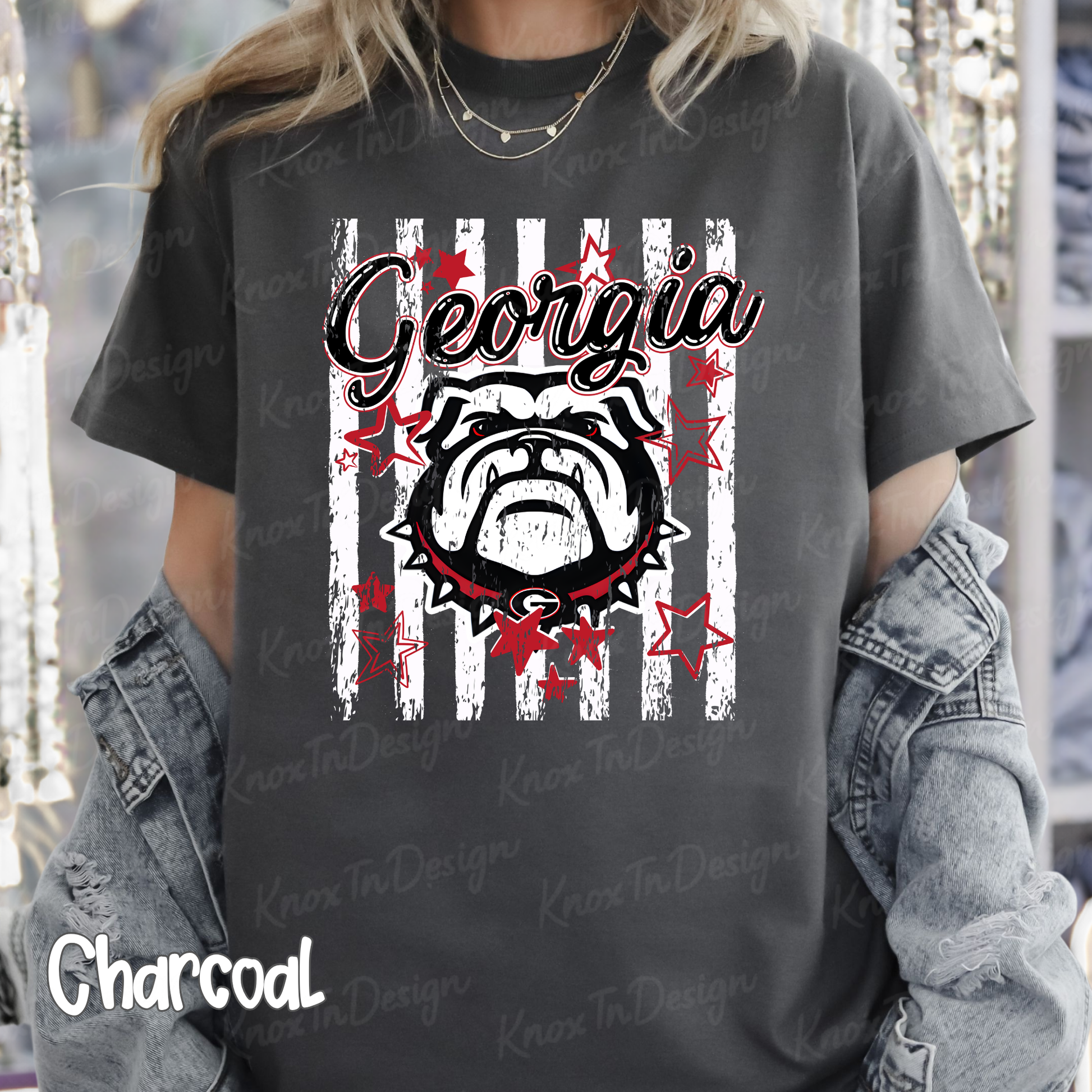 A charcoal gray graphic t-shirt featuring a bulldog design with the word 'Georgia' and red stars, worn by a model with a denim jacket draped off the shoulders.